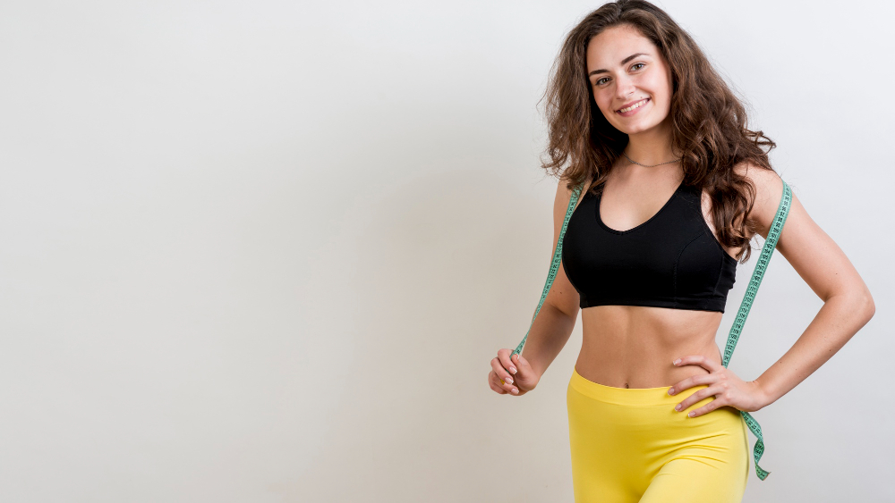 Fit woman with a measuring tape around her shoulders